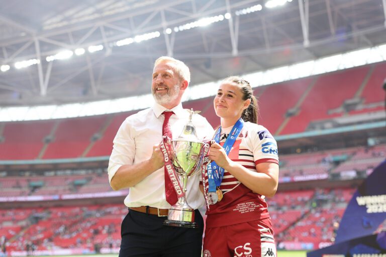 Picture by Alex Whitehead/SWpix.com - 30/05/2026 - Rugby League - Betfred Women's Challenge Cup Final - Wigan Warriors v St Helens - Wembley Stadium, London, England - Wigan coach Denis Betts with Betfred Player of the match Jenna Foubister and the Betfred Women's Challenge Cup trophy after victory over St Helens.